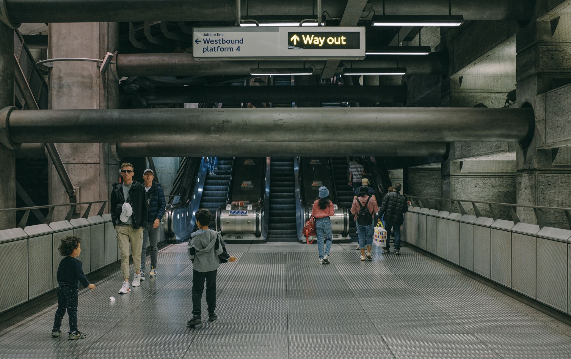 Travelers navigating the busy escalators in a London subway station.