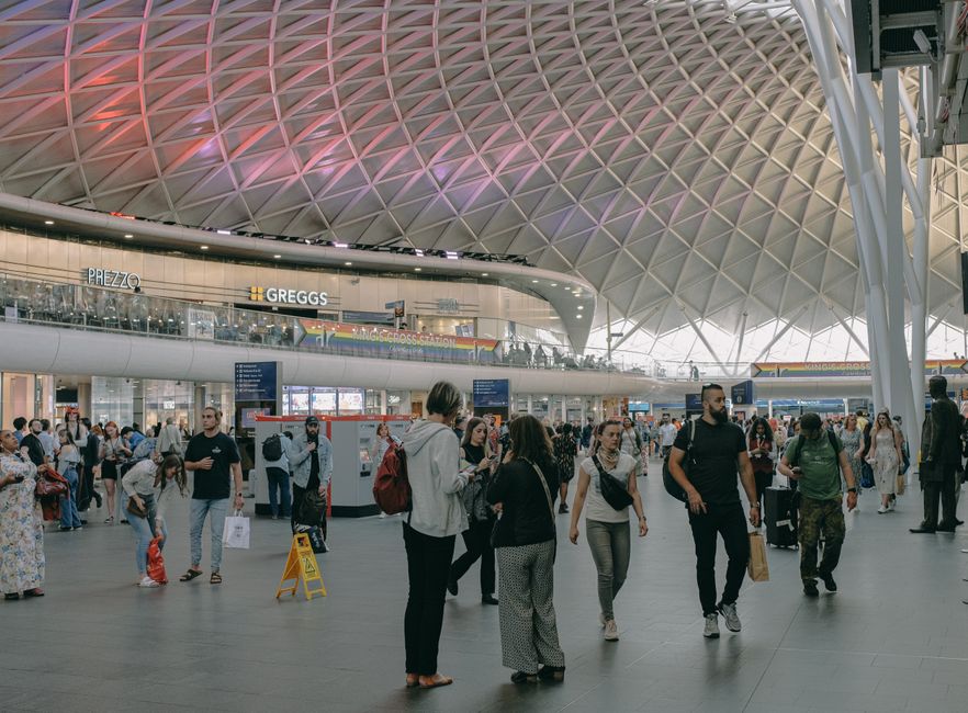 A bustling scene inside King's Cross Station, London, capturing modern architecture and diverse crowd.