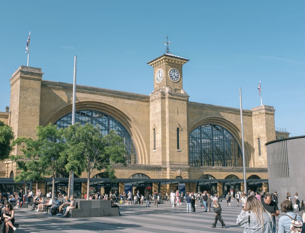 Exteriorul gării King's Cross din Londra, cu turnul cu ceas și piața din față