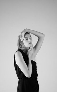 Black and white portrait of a woman posing in a studio setting.