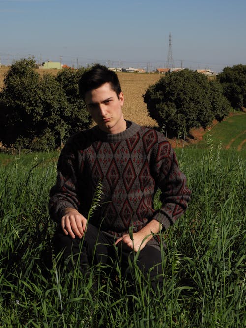 Handsome Man in Old Sweater Posing on Meadow