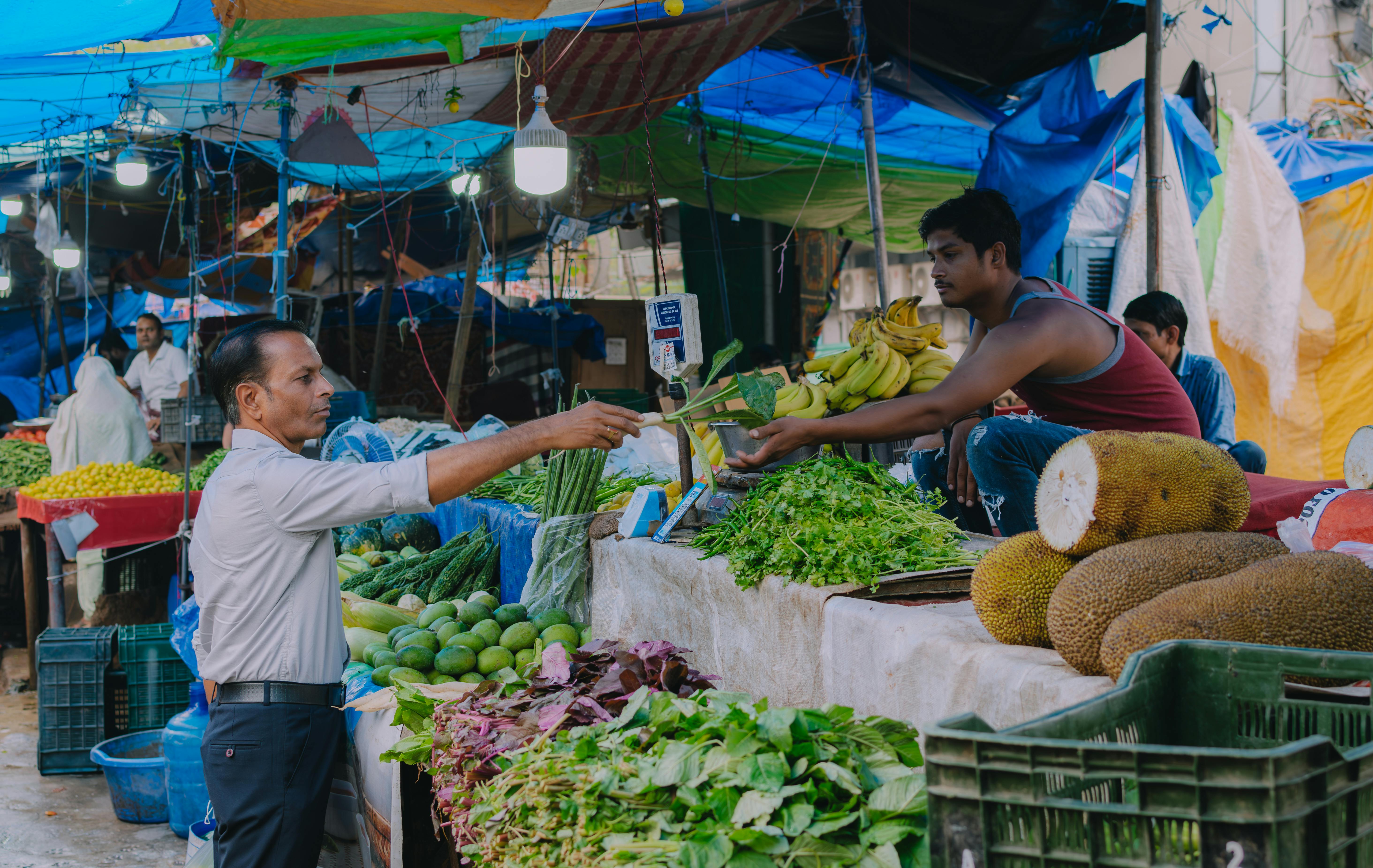 Homem comprando legumes em feira livre, ilustrando o comércio local e a personalização hiperlocal com dados geográficos.