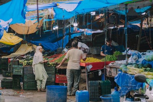 Bustling local market scene with fresh fruits and vegetables and diverse people engaging in commerce.