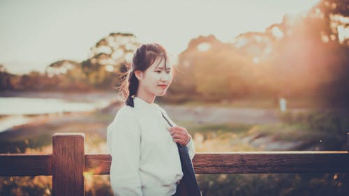 Photo of Woman Standing Beside Fence