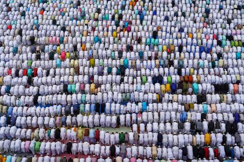 Free Aerial shot of a colorful crowd of people kneeling in prayer, showcasing cultural and religious harmony. Stock Photo