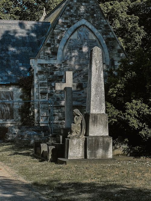 Free A serene stone monument and cross in a historic cemetery setting. Stock Photo