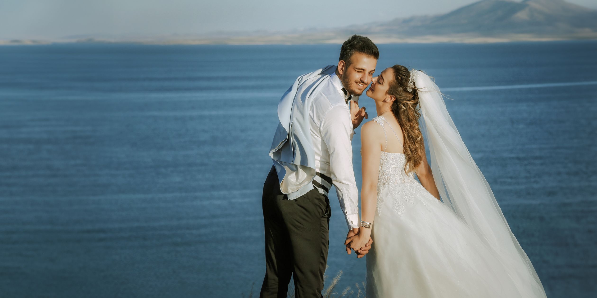 Newlyweds Kissing on Sea Shore · Free Stock Photo
