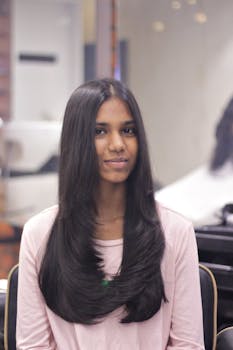 Portrait of a woman with long dark hair, posing indoors in soft lighting.