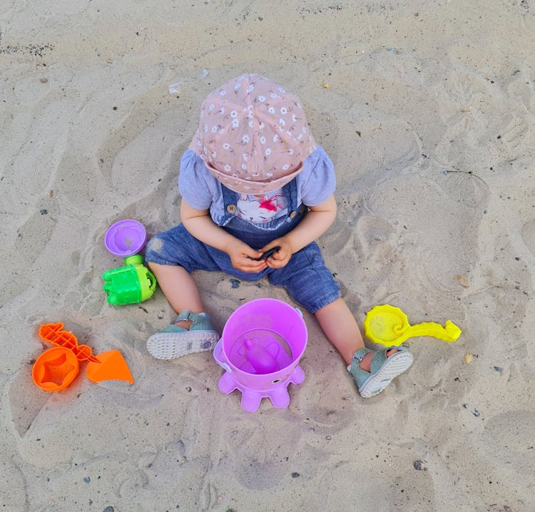 Child Playing With Toys On Sand