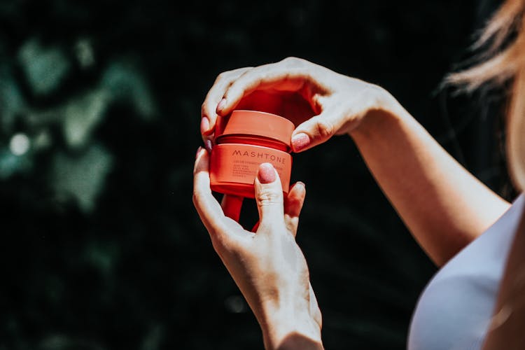 Woman Opening A Jar Of Cream 