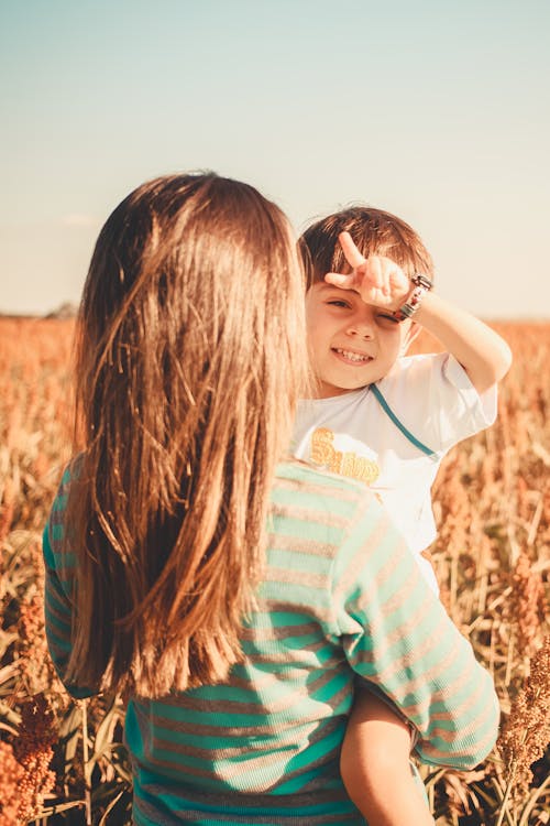 Woman Holding Son on Field