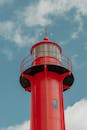 在蔚蓝的天空下，红色灯塔塔显得格外醒目，它散发出充满活力的气息