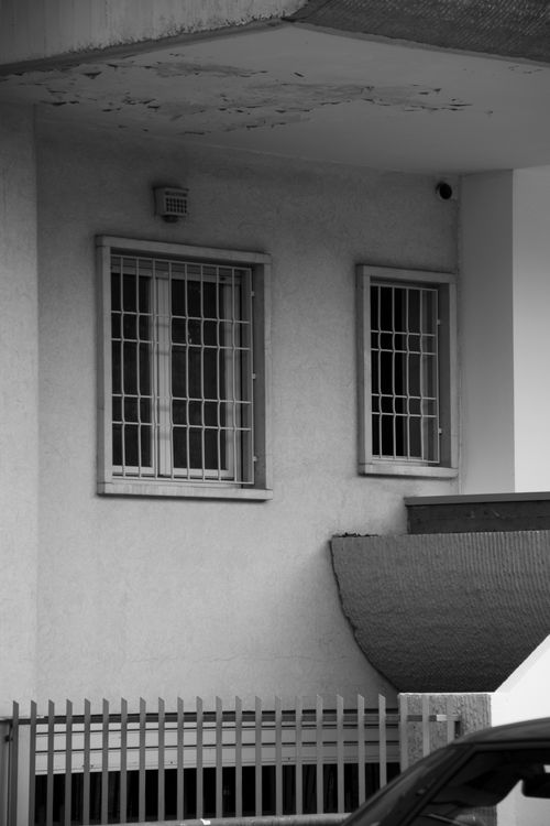 Free Black and white image of building facade with grilled windows in Brescia, Italy. Stock Photo
