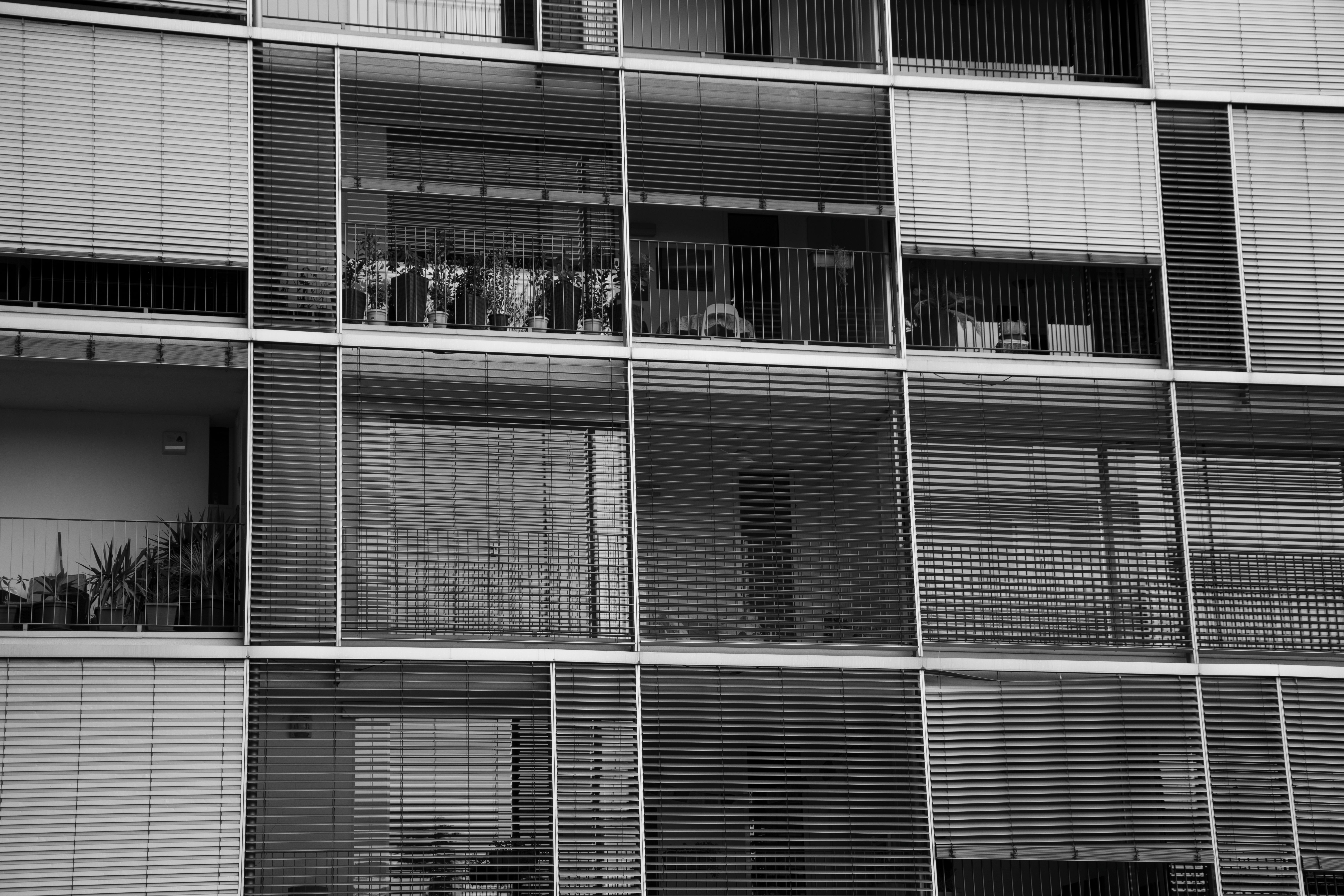Black and white view of a modern apartment building facade in Brescia, Italy.