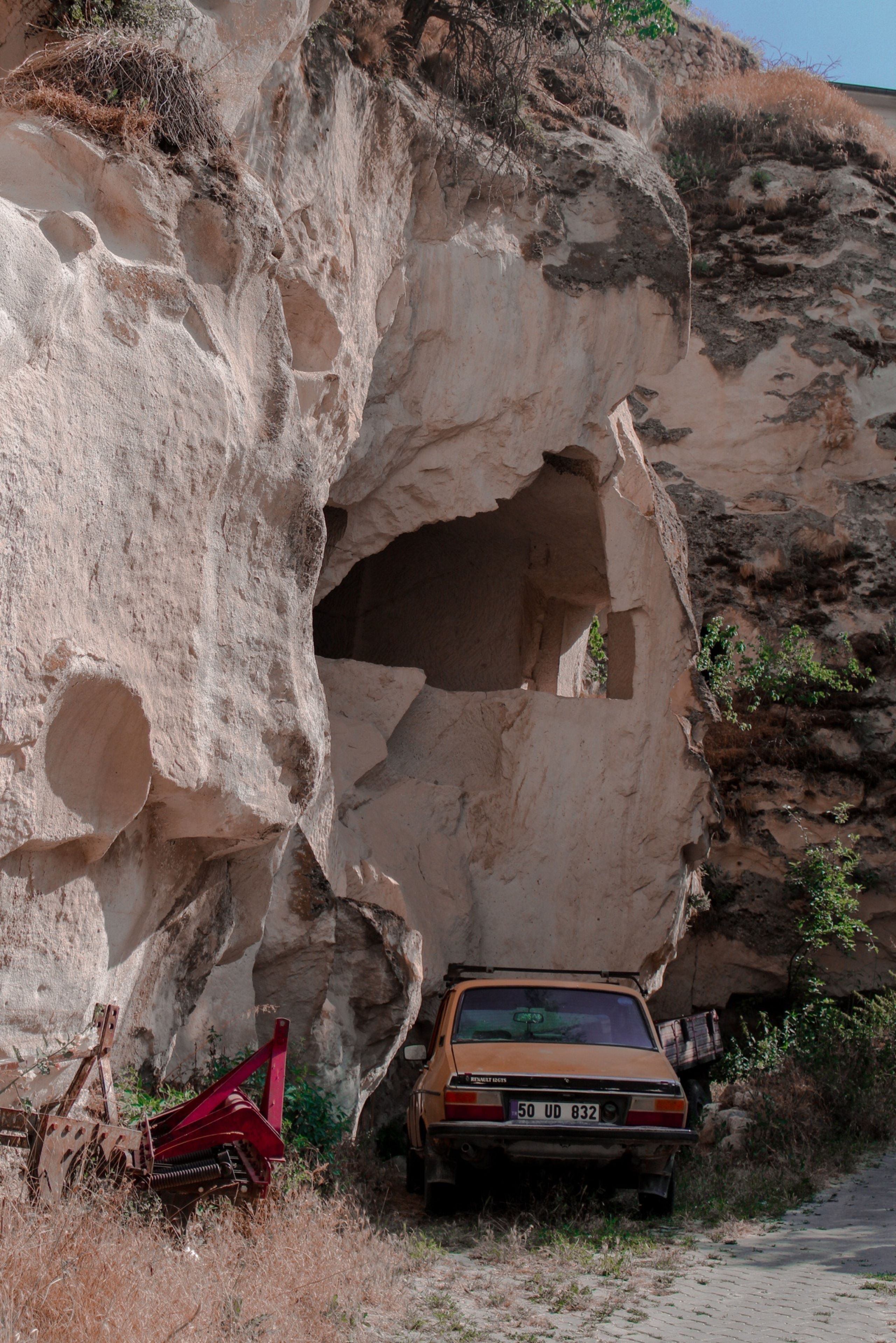 A vintage car parked by Cappadocia's iconic carved rock formations, capturing the essence of Türkiye's unique landscape.