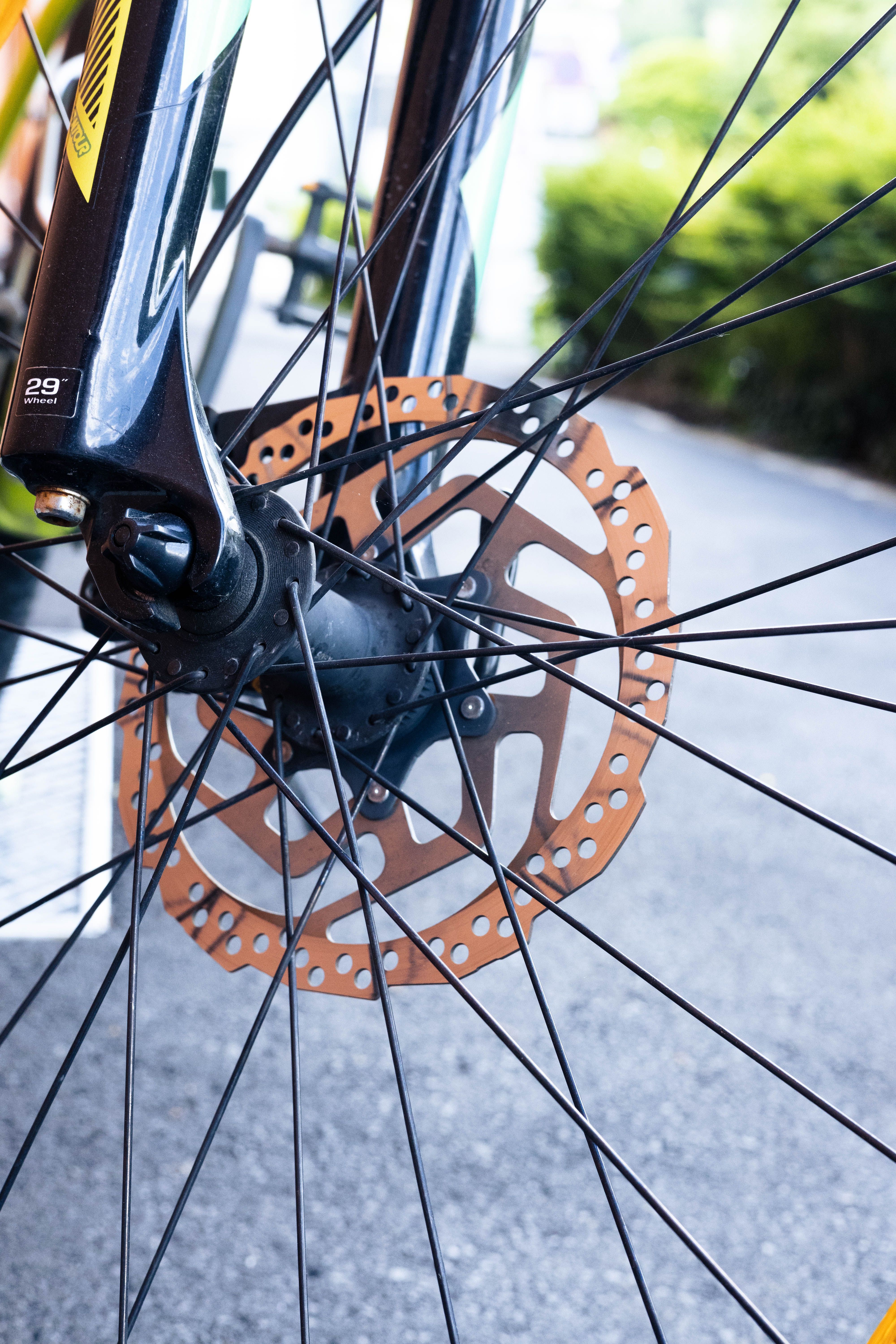 Detailed shot of a bicycle wheel featuring a disc brake with metal spokes.
