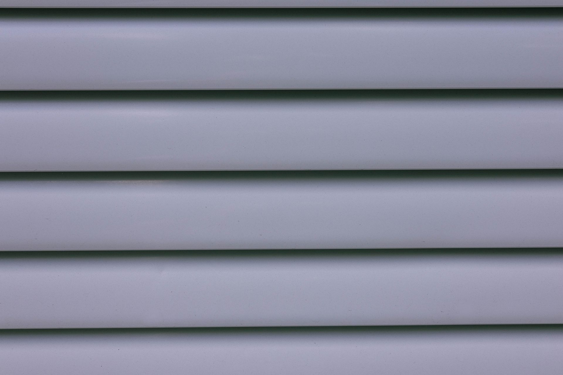 Detailed close-up of gray layered wall paneling showing lines and shadows.