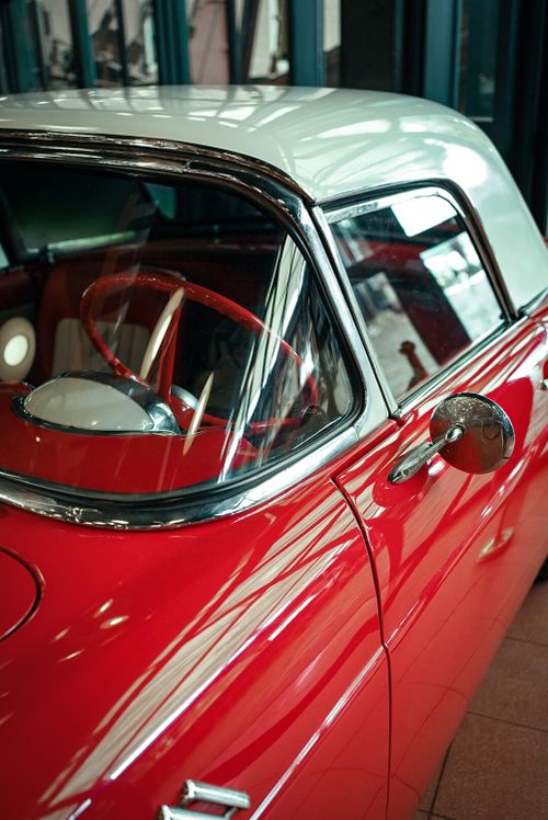 Free A vintage red convertible displayed in an indoor garage setting, showcasing its classic design. Stock Photo