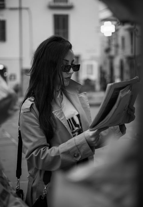 Free Brunette Woman Reading Magazine on Street Stock Photo