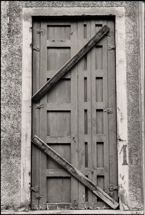 Black and White Photo of an Old Boarded Up Wooden Door