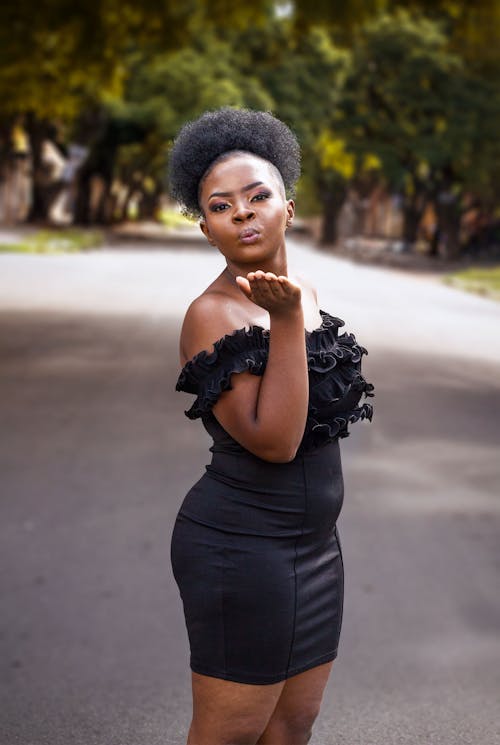 Woman in a Black Dress Posing Outside 