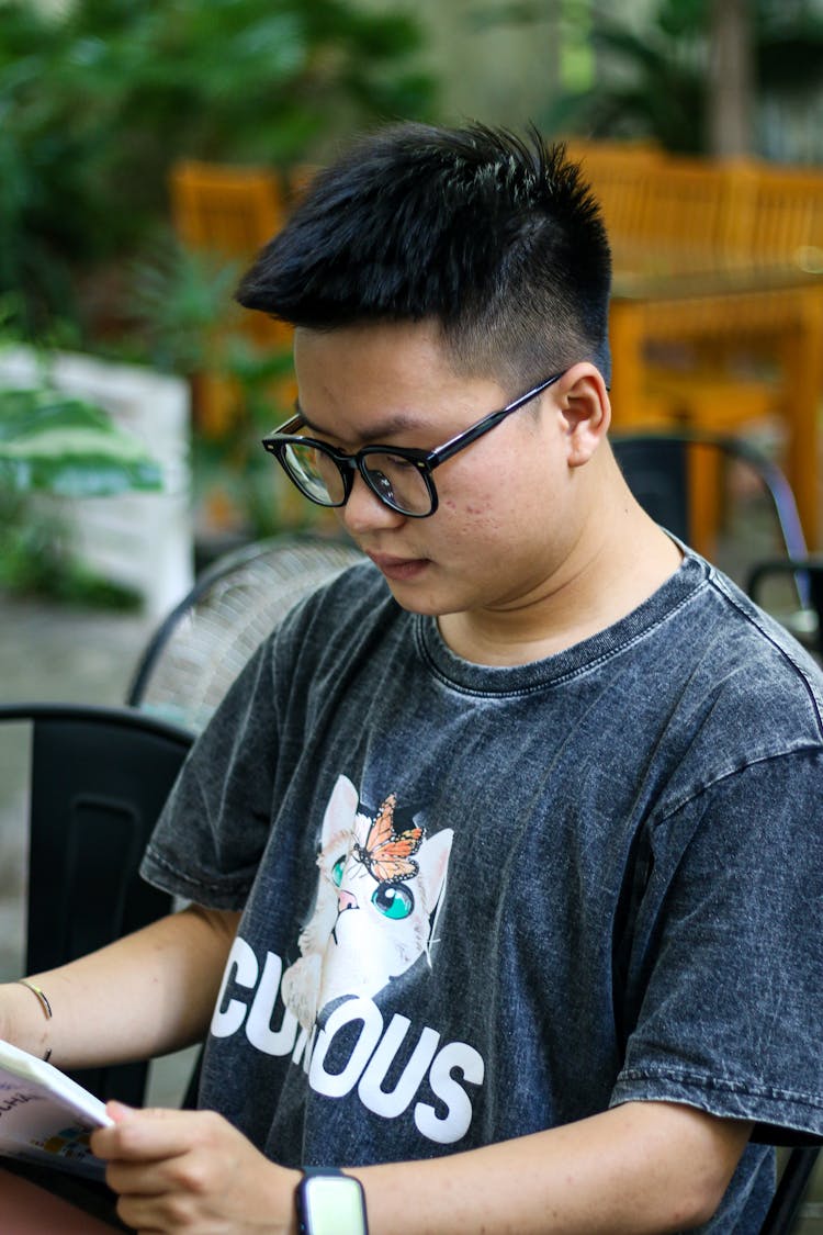 Guy In Glasses Sitting On Bench Reading Book