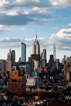 Stunning view of New York City skyline with the iconic Empire State Building under a cloudy sky.