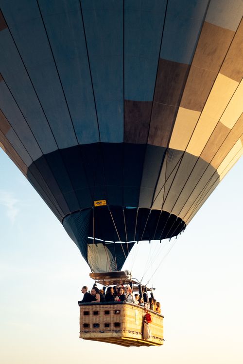 Free Diverse group enjoying a scenic hot air balloon flight against a clear sky. Stock Photo