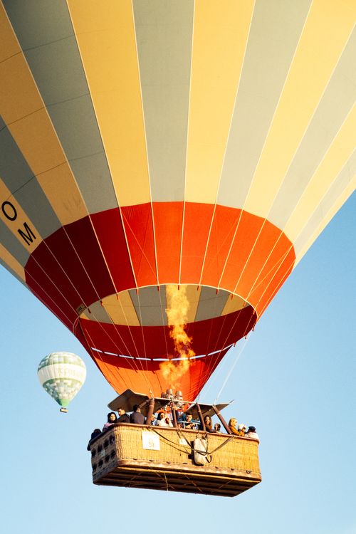 Free A vibrant hot air balloon floats against a clear blue sky, capturing the adventure of flight. Stock Photo