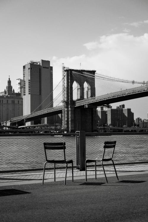 Two Chairs on Waterfront against Brooklyn Bridge