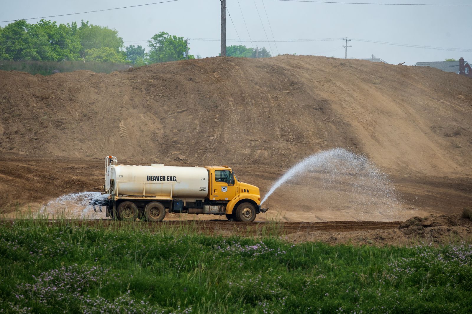 Water tanker spraying water across a construction site