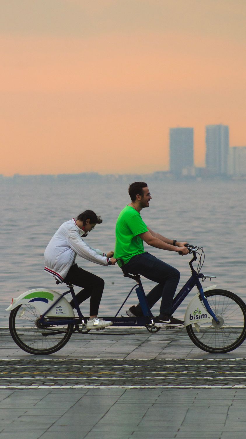 Motorcycle Riding In Tandem Couple Riding Tandem Bike on Promenade at Sunset · Free Stock Photo
