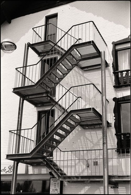 Free Black and white vertical view of an urban fire escape with metal stairs. Stock Photo