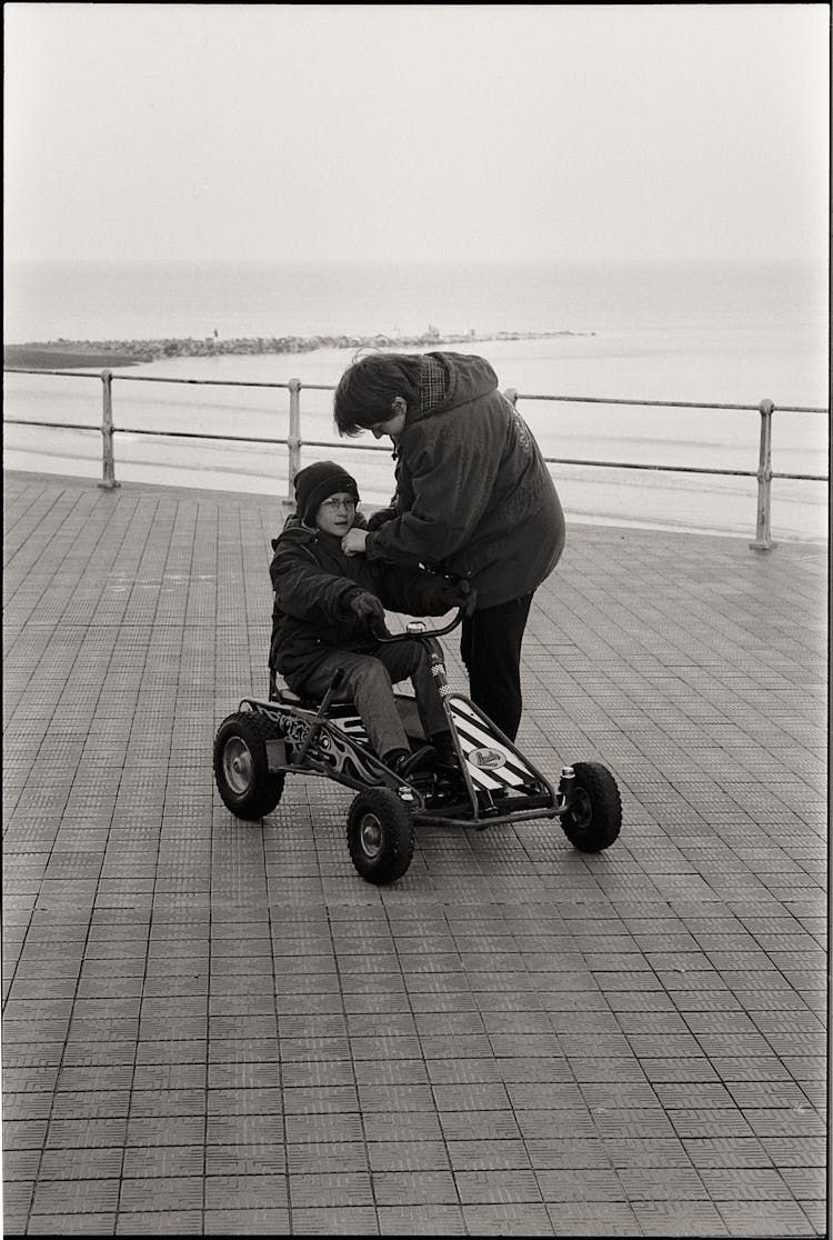 Woman Zipping Up Jacket Of Child On Bicycle