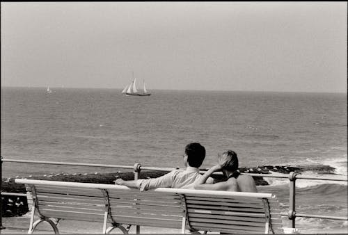 Couple Sitting on Bench on Seashore