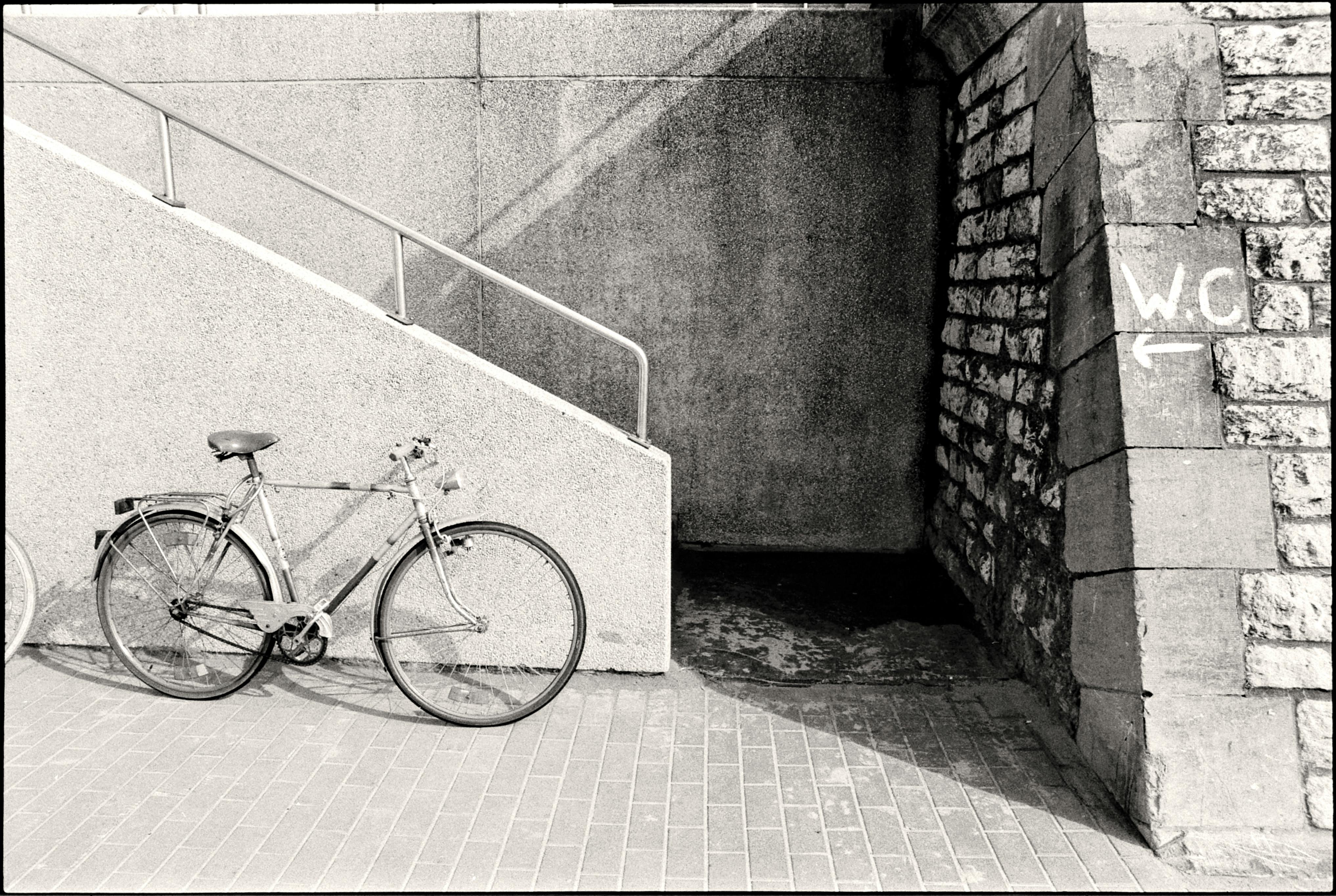 Black and White Photo of Bicycle Parked under White Wall · Free Stock Photo