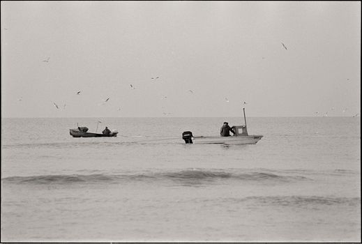 Black and White Picture of Men in Boats on the Sea 