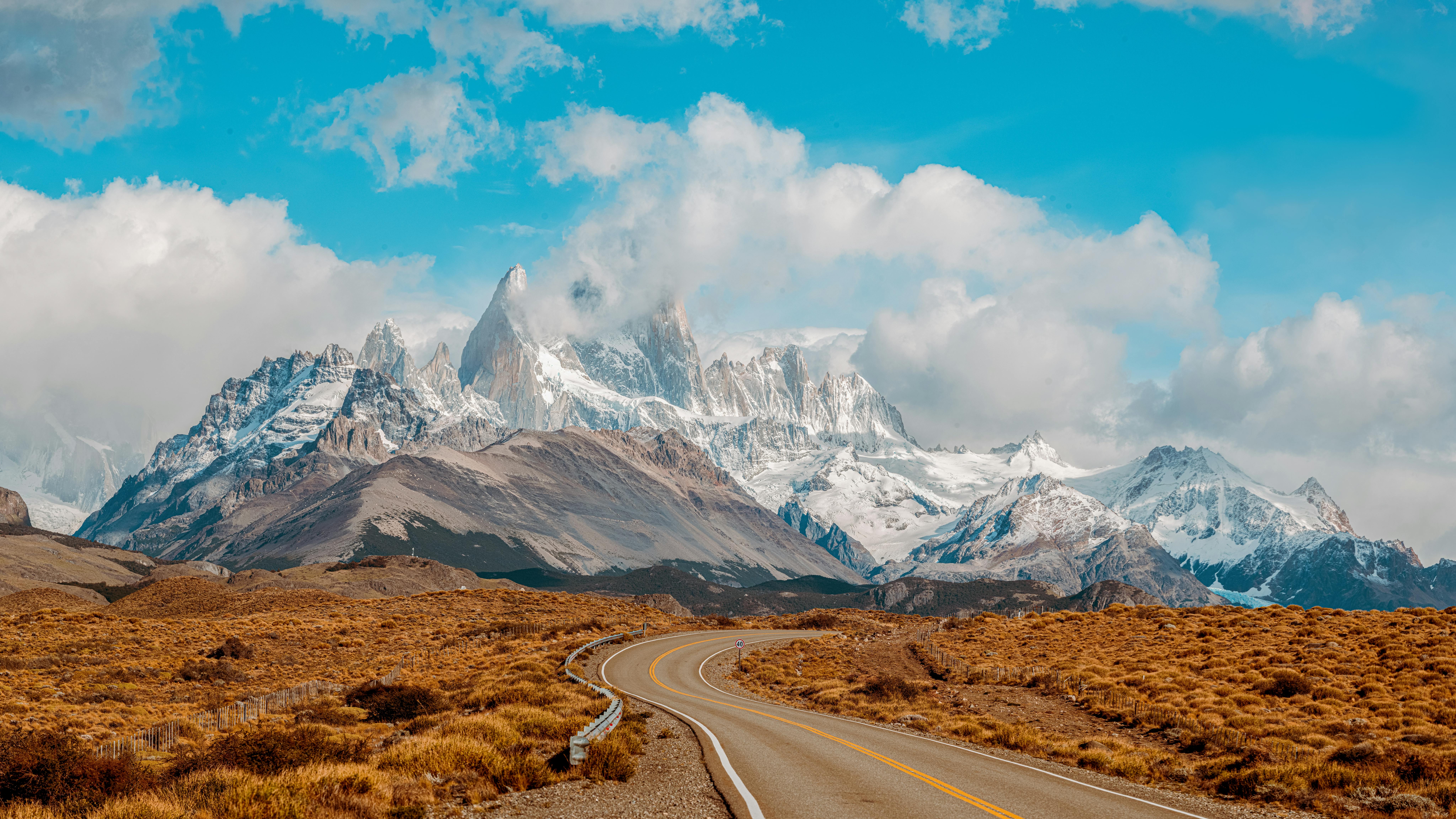 Discover the stunning view of Mount Fitz Roy in Patagonia, Argentina, with a winding road leading to the majestic peaks.