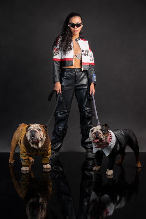 Woman in Racing Suit Standing with Dogs