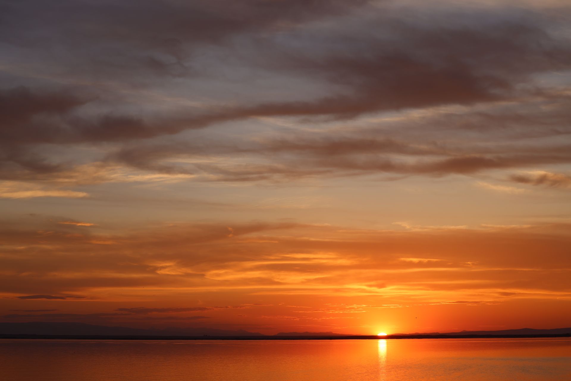 Breathtaking sunset with vibrant colors casting reflections on Moses Lake, Washington.