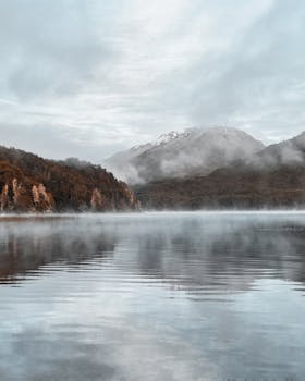 Scenic view of a misty lake surrounded by mountains in Patagonia, Argentina.