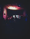 在黑暗的夜总会环境中，剪影乐队用彩色灯光在舞台上进行现场表演