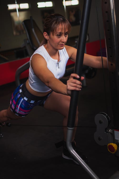 Photo of Woman Working out Using Gym Equipment Inside Gym