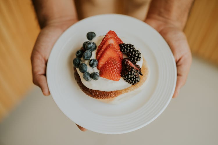 Hands Holding Plate With Cake