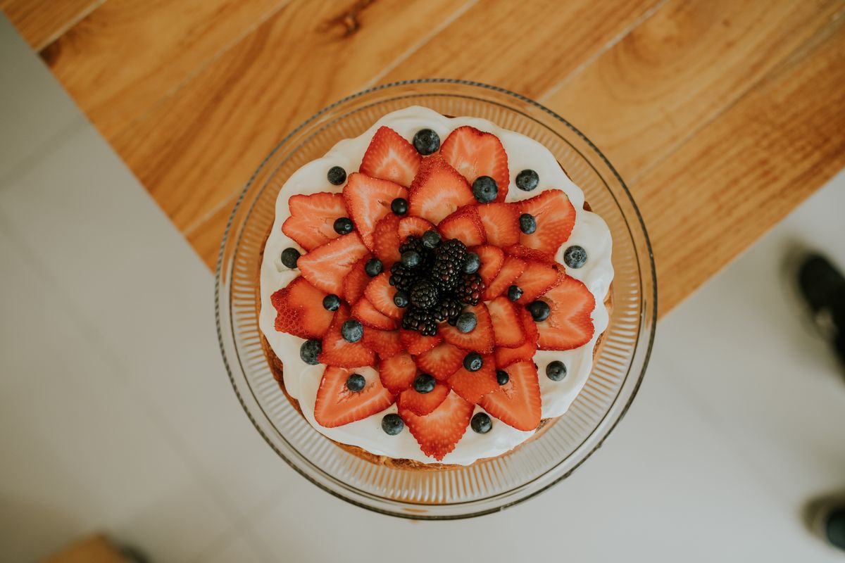 Fruit-topped sponge cake with cream and fresh berries