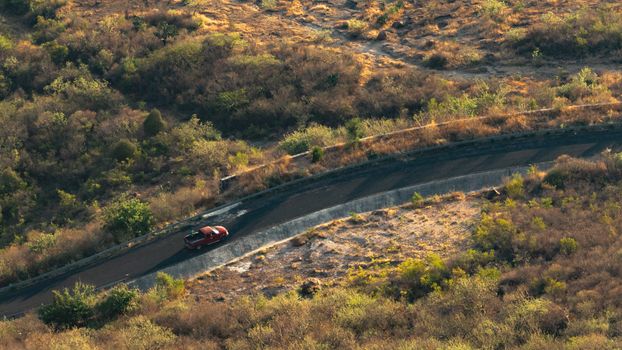 Aerial view of a car navigating a winding road in rural Atlixco, Mexico.