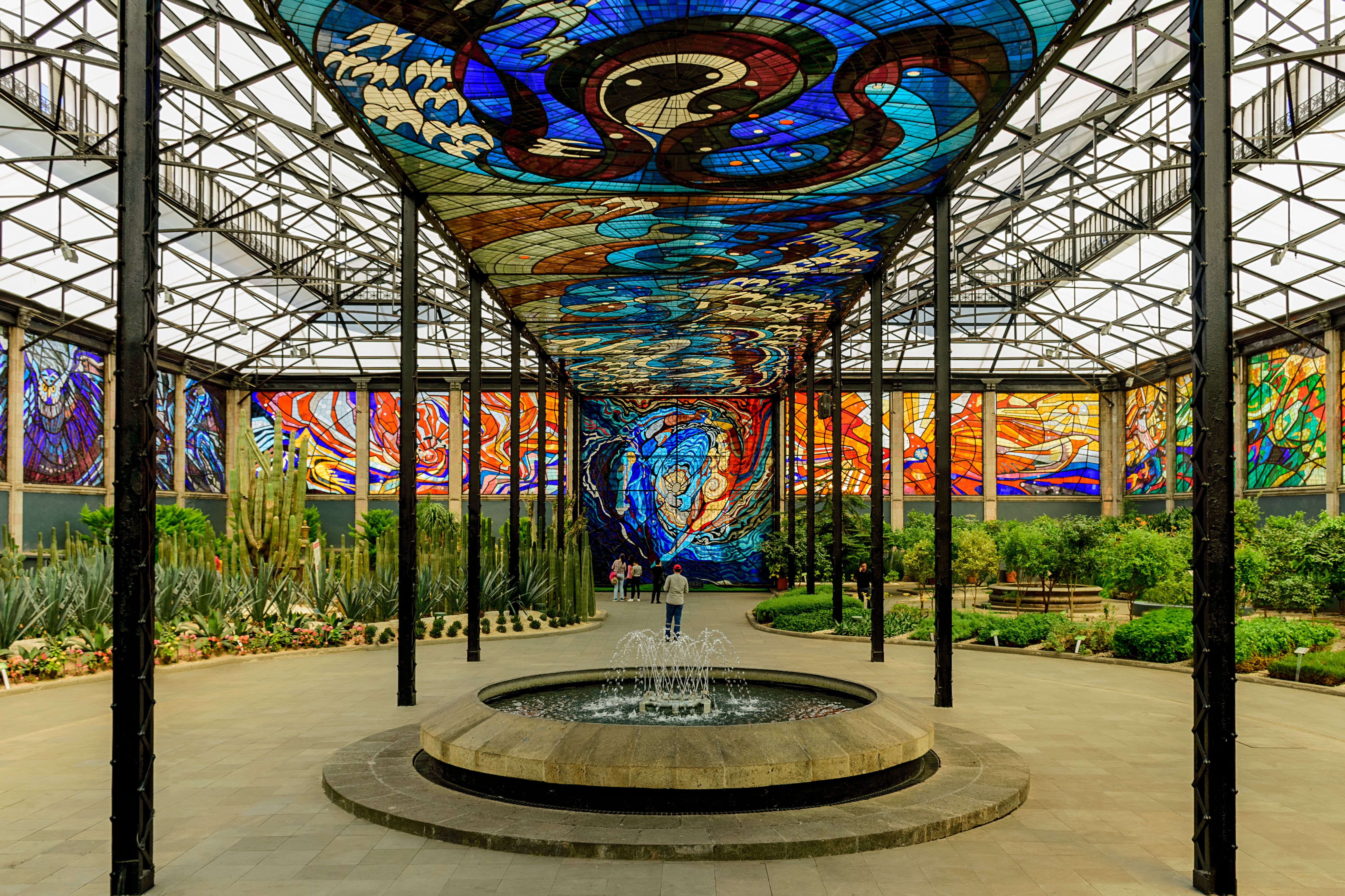 Stunning stained glass and garden at Cosmovitral, Toluca's landmark, featuring vibrant colors and lush greenery.