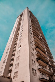 现代高层建筑在低角度下清晰可见，背景是明朗的蓝天