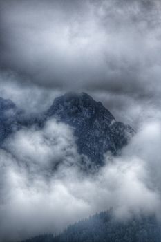Capture the awe of the Tatra Mountains enveloped in mist and clouds in Zakopane, Poland.