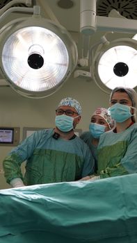 Team of surgeons in operating room performing surgery with focus on teamwork and precision.